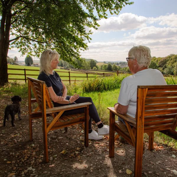 A private, one-to-one counselling session between two people overlooking the countryside